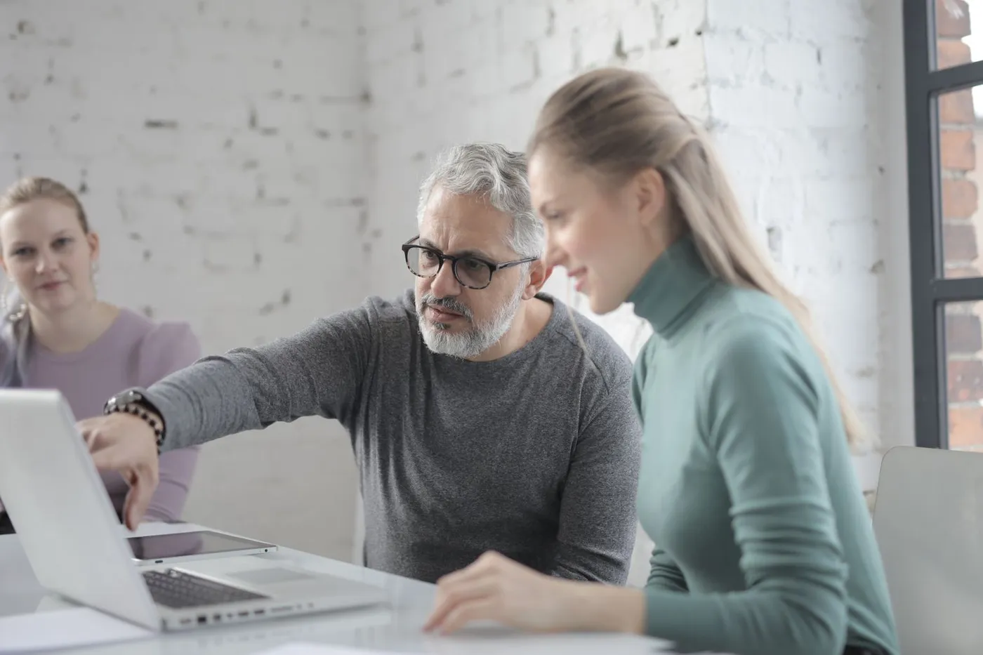 Un formateur guide une apprenante sur un ordinateur portable